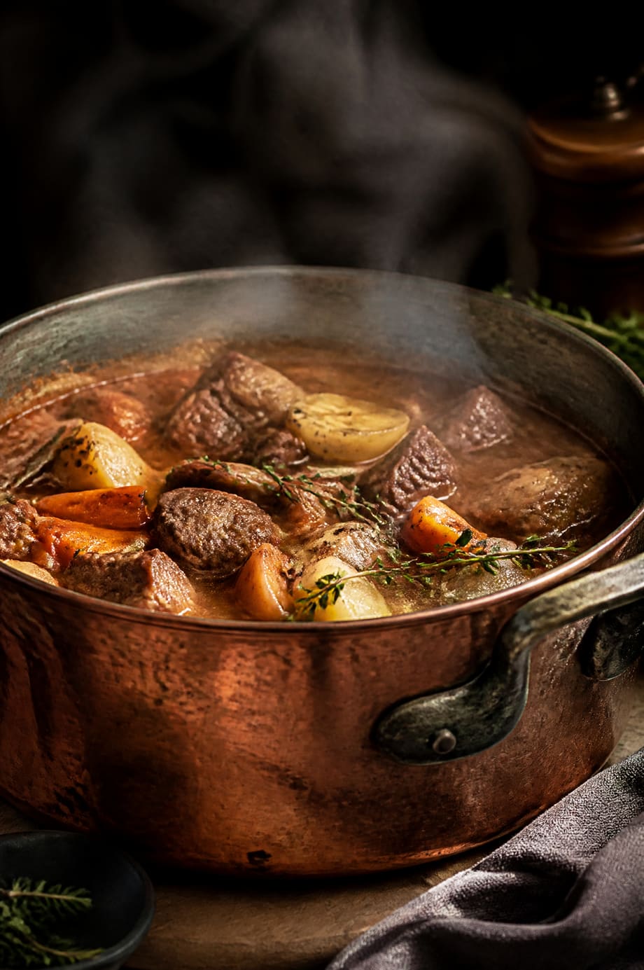 Cocotte en cuivre fumante garnie d'un plat mijoté